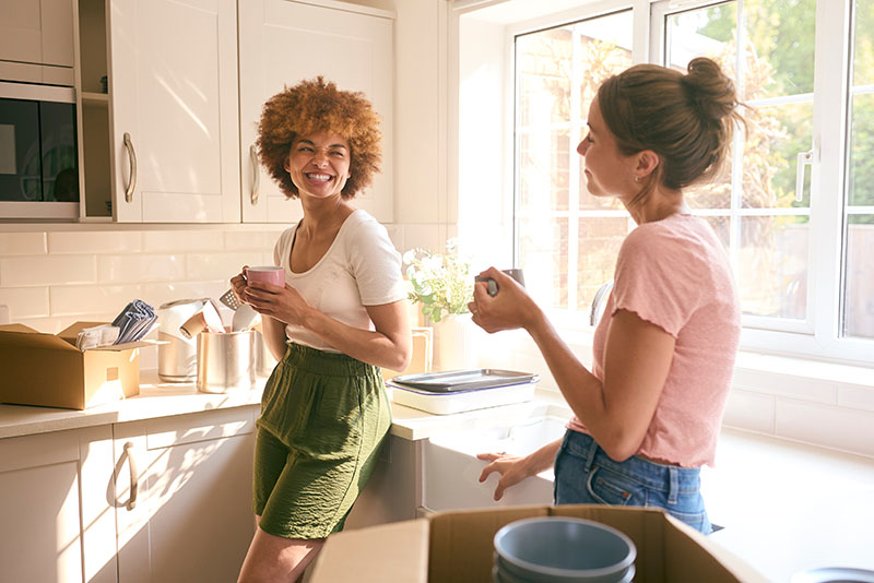 Two women drinking coffee in the kitchen