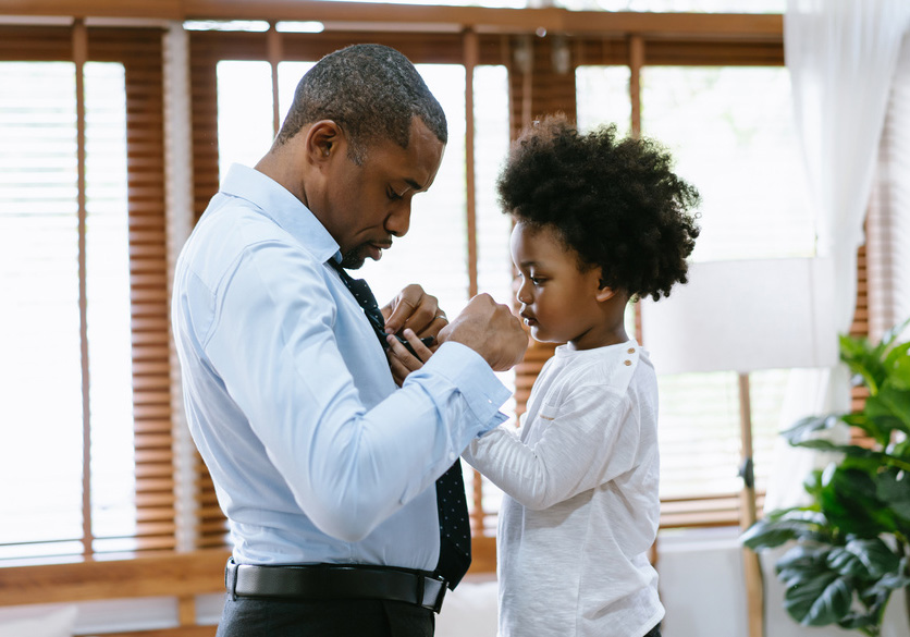 Picture of man teaching his son how to tie a tie